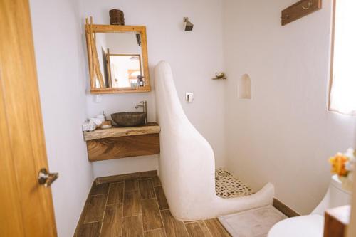 ein Badezimmer mit einem weißen Waschbecken und einem Spiegel in der Unterkunft Hotel Boutique casa la Malagueña in San Agustinillo