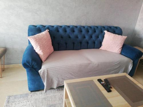 a blue couch in a living room with a table at Appartement Résidence fermée in Casablanca