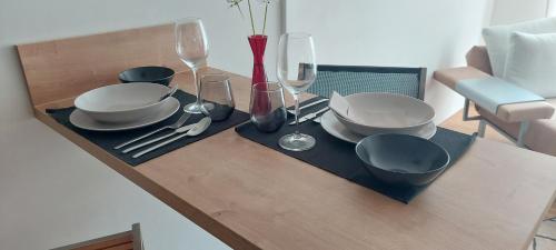 a table with plates and wine glasses on top of it at Holzer 2.0 in Brannenburg