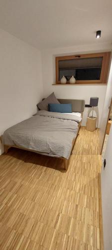 a bedroom with a bed and a wooden floor at Holzer 2.0 in Brannenburg
