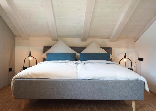 1 dormitorio con 1 cama grande y 2 lámparas en Holzer 2.0, en Brannenburg