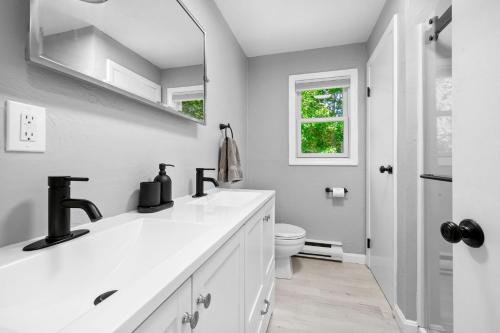 een witte badkamer met een wastafel en een toilet bij 35 Pinecrest Avenue Mashpee Bela Vida in Mashpee