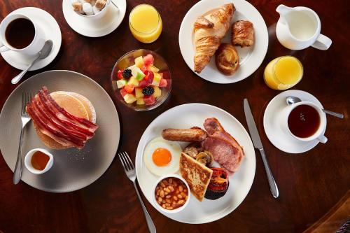 Una mesa cubierta con platos de desayuno y café. en Macdonald Highlands Hotel at Macdonald Aviemore Resort, en Aviemore
