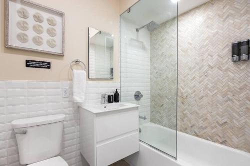 a white bathroom with a toilet and a shower at SWJ 2nd - Times SQ, Brooklyn Bridge, LGA in 15 min in New York