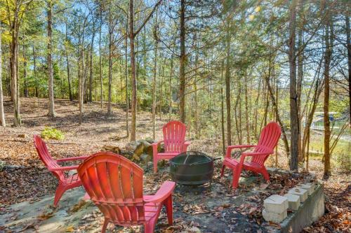 a group of red chairs around a fire pit at Lovely Lake Hartwell Retreat with Dock and Grill! in Hartwell
