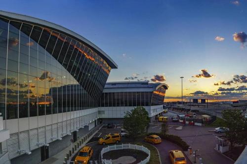 a large building with cars parked in a parking lot at SWJ 2nd - Times SQ, Brooklyn Bridge, LGA in 15 min in New York