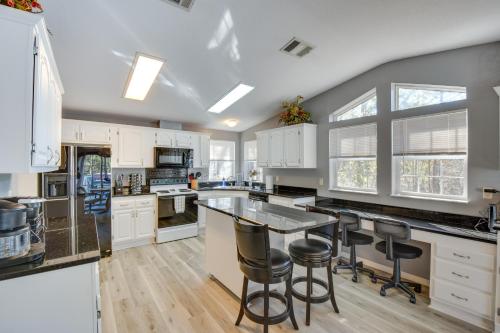 a kitchen with white cabinets and a large island with bar stools at Lovely Lake Hartwell Retreat with Dock and Grill! in Hartwell