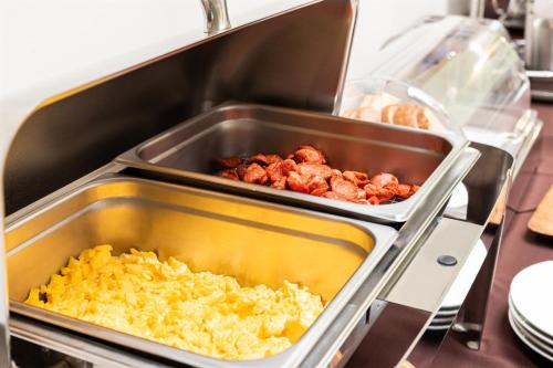 a kitchen with two trays of food on a stove at Apartotel Tairona in San Pedro