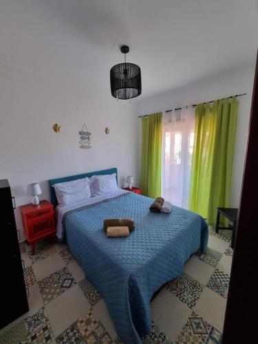 Casa Sol e Mar : غرفة نوم مع سرير مع دمية دب عليها