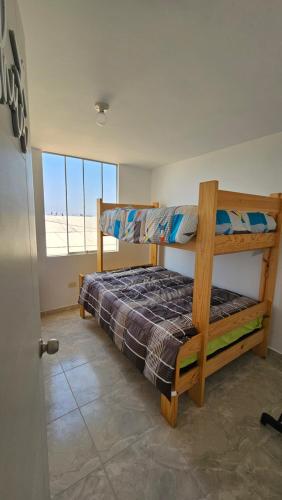 a bedroom with a bunk bed and a window at Departamento amoblado Huanchaquito in Huanchaco