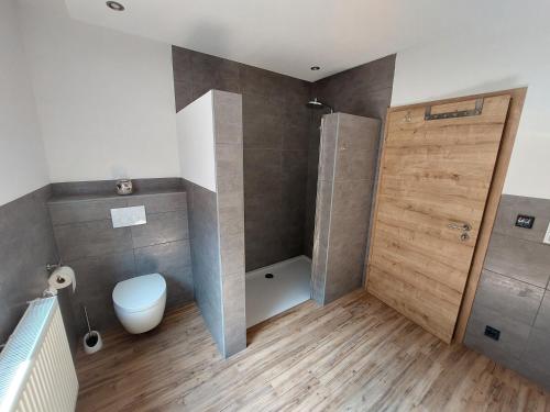 łazienka z prysznicem, toaletą i drzwiami w obiekcie Ferienwohnung-Bergblick w mieście Bad Bocklet