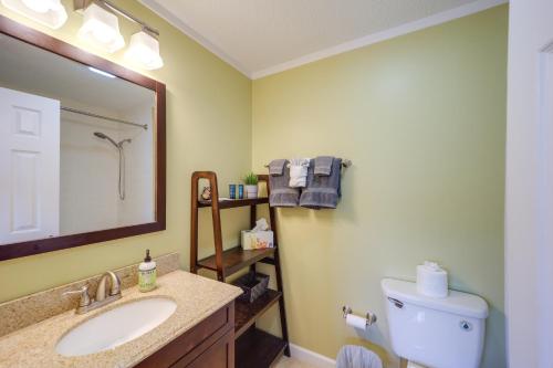 a bathroom with a sink and a toilet and a mirror at Cozy Sugar Mtn Condo with AandC - Walk to Ski and Golf! in Sugar Mountain