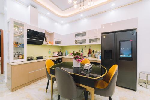 uma cozinha com uma mesa de jantar e cadeiras amarelas em Út Thảo 2 em Da Lat