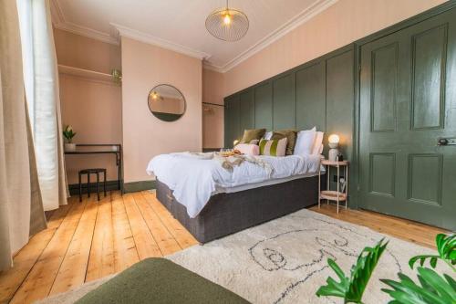 1 dormitorio con cama y pared verde en Kim's City Escape, en Cardiff