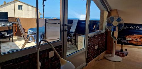 a room with a balcony with a fan and a window at RINCON DO MAR ATC DH in A Guarda