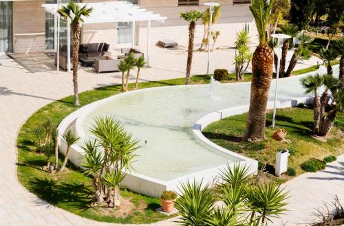 an empty pool with palm trees in a courtyard at Regiohotel Manfredi in Manfredonia