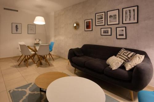sala de estar con sofá negro y mesa en Apartamento La Calma, en Lliber