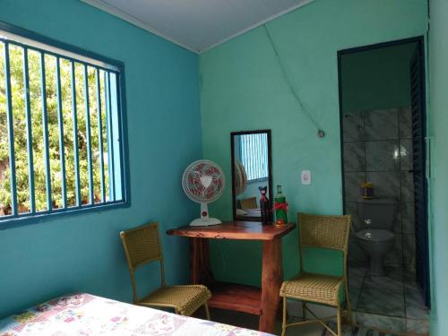 um quarto azul com uma mesa, cadeiras e um espelho em Pousada Joao & Maria em Pirenópolis