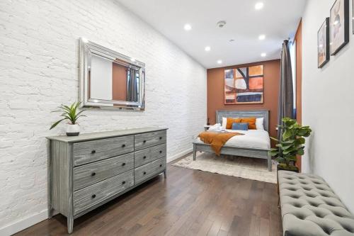 a bedroom with a bed and a dresser with a mirror at SWJ 3rd - Sleeps 7,Close to LGA,Times Sq in 25 min in New York