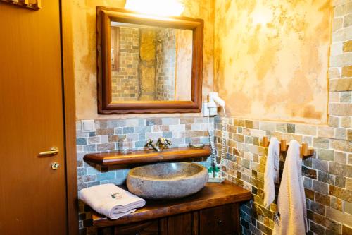 bagno con lavandino e specchio di Apolithomeno Dasos Holiday Villas a Lefkimmi