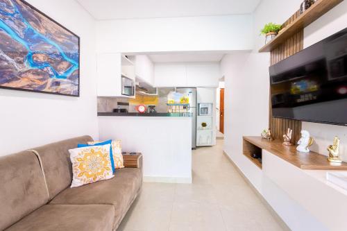 ein Wohnzimmer mit einem Sofa und einer Küche in der Unterkunft Crôa Residence in Maragogi