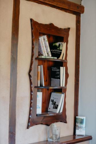 a mirror on a wall with a shelf with books at Apolithomeno Dasos Holiday Villas near Alexandroupolis in Lefkimmi