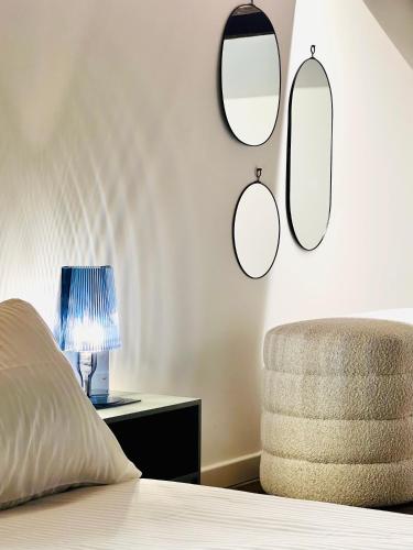 a bedroom with a bed and a chair and mirrors at Tarra Luxury Suite in Milan