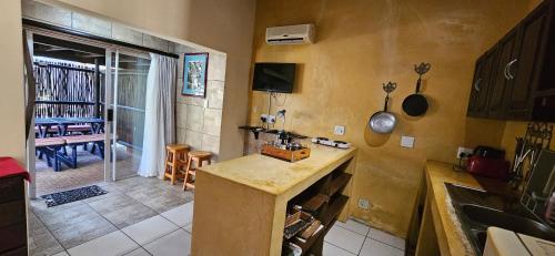 a kitchen with a counter and a table in it at Old Vic Travellers Inn Nelspruit in Nelspruit