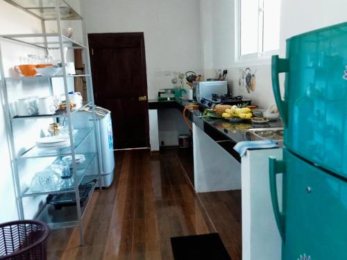 a kitchen with blue appliances and a wooden floor at Inn Sea Horizon Ahungalla in Ahungalla