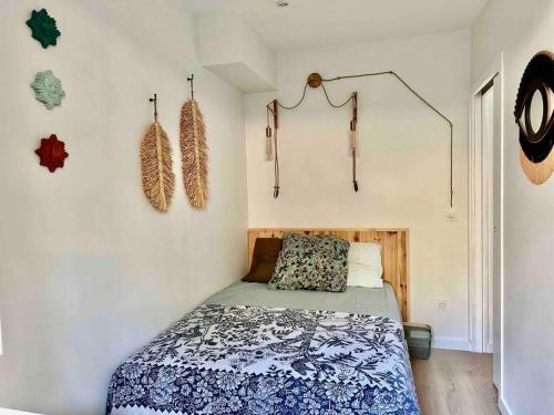 ein Schlafzimmer mit einem Bett mit einer blauen und weißen Decke in der Unterkunft Le repaire de la Vierge bohème vue mer in Cassis