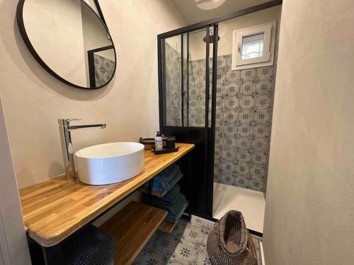 une salle de bain avec un lavabo et un miroir dans l'établissement Le repaire de la Vierge bohème vue mer, à Cassis