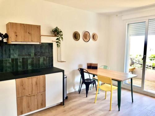 une cuisine et une salle à manger avec une table et des chaises dans l'établissement Le repaire de la Vierge bohème vue mer, à Cassis