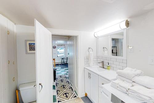 een witte badkamer met een wastafel en een spiegel bij Seaside Cottage in Bristol