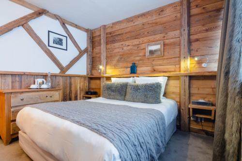 a bedroom with a bed and a wooden wall at Hotel 3 Vallées Val Thorens in Val Thorens