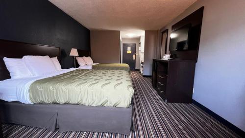 a hotel room with a bed and a television at Colby Inn and Suites in Colby