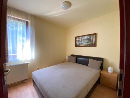 a bedroom with a large bed with a window at Siófoki Beach Apartman in Siófok