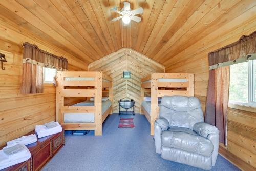 uma cabina de madeira com um quarto, uma cama e uma cadeira em Soldotna Fishing Lodges with Dock on Kenai River! em Sterling