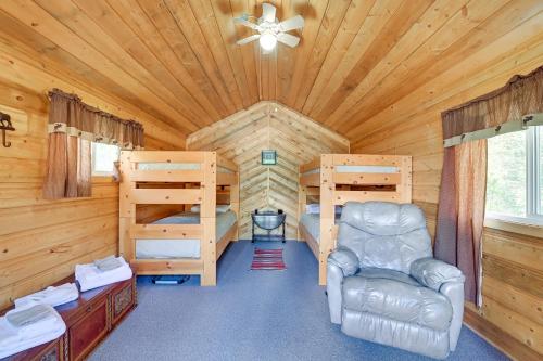 a log cabin with a bedroom and a bed and a chair at Soldotna Fishing Lodges with Dock on Kenai River! in Sterling
