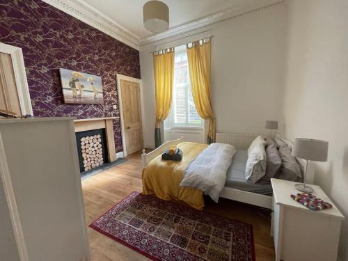 Schlafzimmer mit einem Bett, einem Tisch und einem Fenster in der Unterkunft Stunning West End Flat! in Glasgow