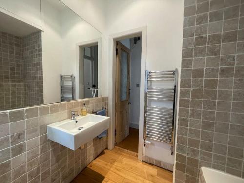 a bathroom with a white sink and a mirror at Stunning West End Flat! in Glasgow