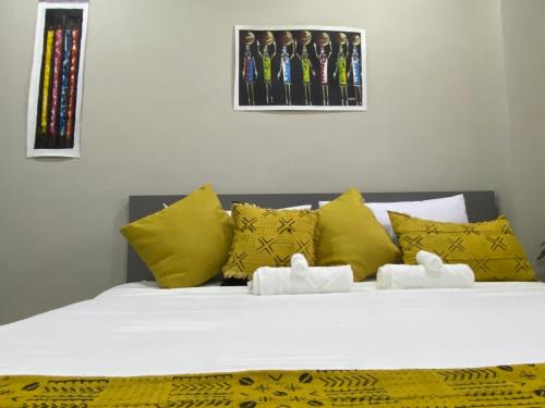 um quarto com uma cama com almofadas amarelas em Newly Renovated 1Bd Apt in Heart of Osu em Acra