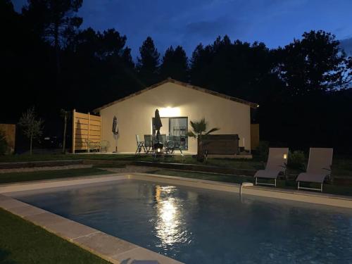 a swimming pool in front of a house at night at Villa La source & SPA in Pont-de-Labeaume