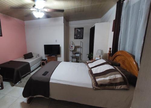 1 dormitorio con 2 camas y TV de pantalla plana en Tocumen Sweet Home, en Cabuya