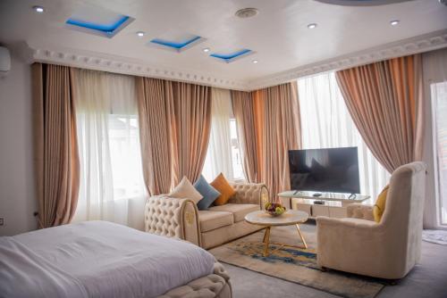 MONDEESTARS LUXURY HOME في إيبادان: غرفة نوم بسرير واريكة وتلفزيون