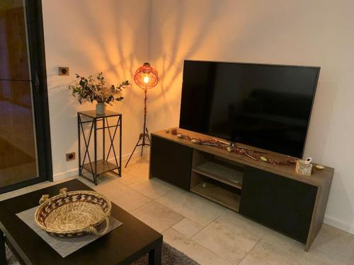 a living room with a large flat screen tv at Villa La source & SPA in Pont-de-Labeaume