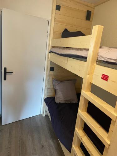 a room with two bunk beds and a door at Studio tout confort in Barcelonnette