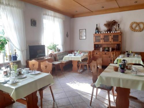una sala da pranzo con 2 tavoli e una TV di Hotel zur Post a Klingenthal