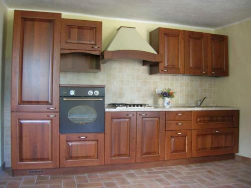 a kitchen with wooden cabinets and an oven at Appartamento in pieno relax in Saint Nicolas
