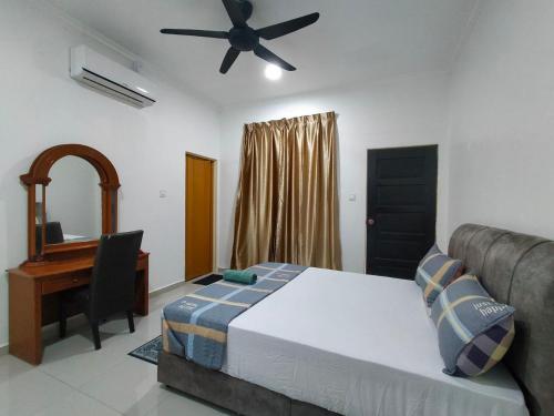 a bedroom with a bed and a desk and a ceiling fan at RoofTop Villa in Malacca