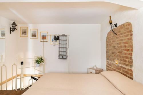 ein Schlafzimmer mit einem Bett und einer Ziegelwand in der Unterkunft Monolocale "Duomo" in Messina